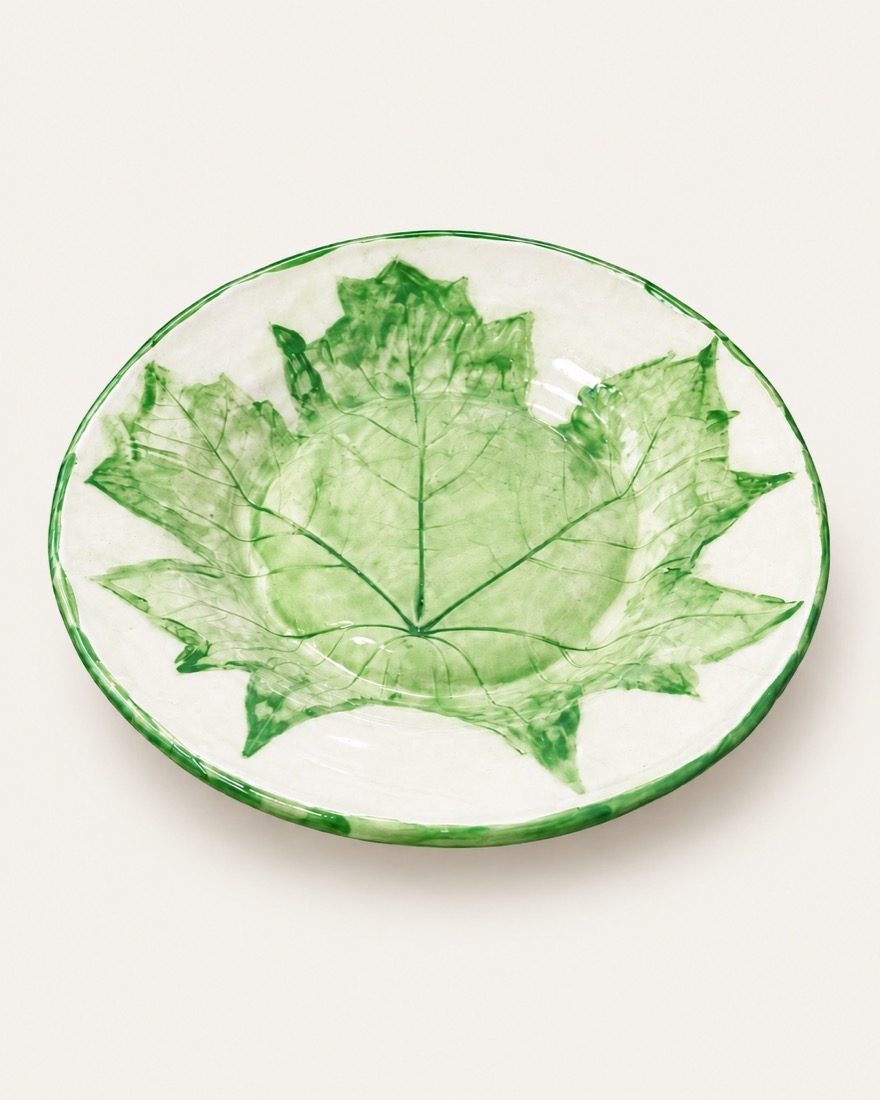 Plato blanco con una gran hoja verde impresa y el borde pintado en verde