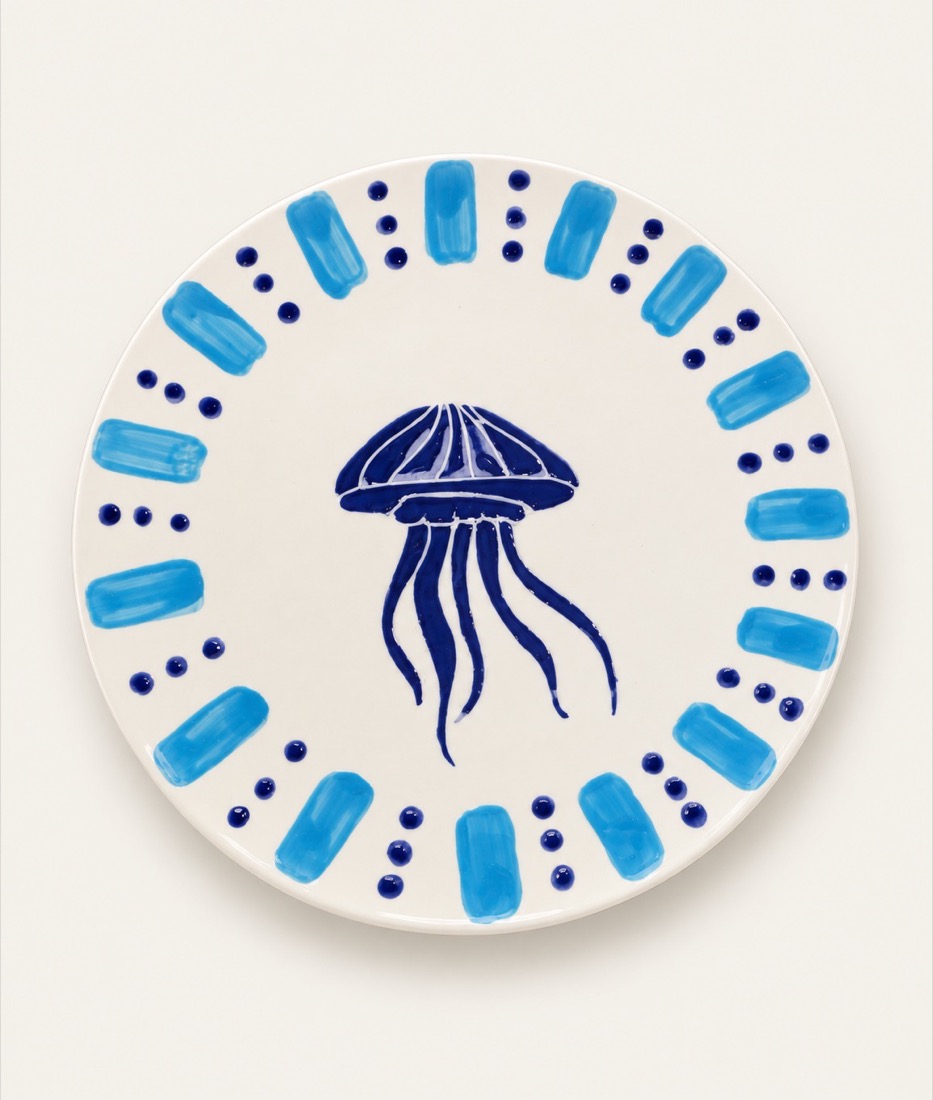 Plato blanco con una medusa azul en el centro y una cenefa de trazos azules y puntos